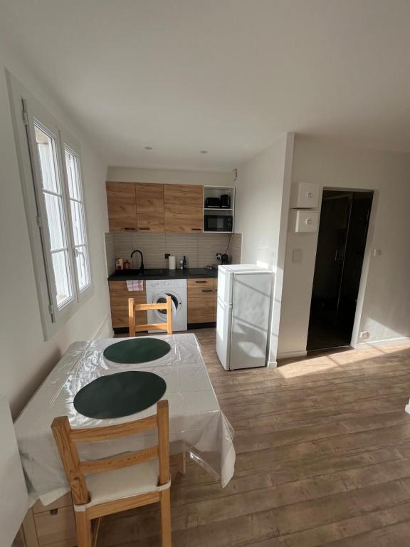 une cuisine avec une table, des chaises et un réfrigérateur dans l'établissement Studio Intra-Muros idéal festivalier Climatisé, à Avignon