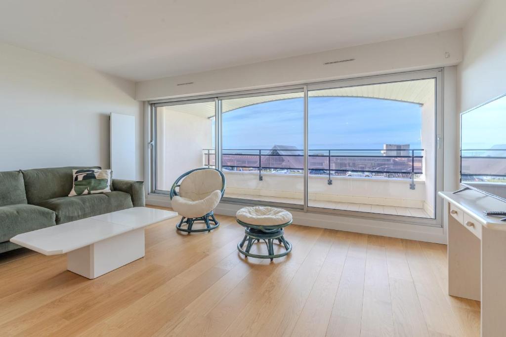un salon avec un canapé et une grande fenêtre dans l'établissement Sea-facing apartment for 4 people, à Le Touquet-Paris-Plage