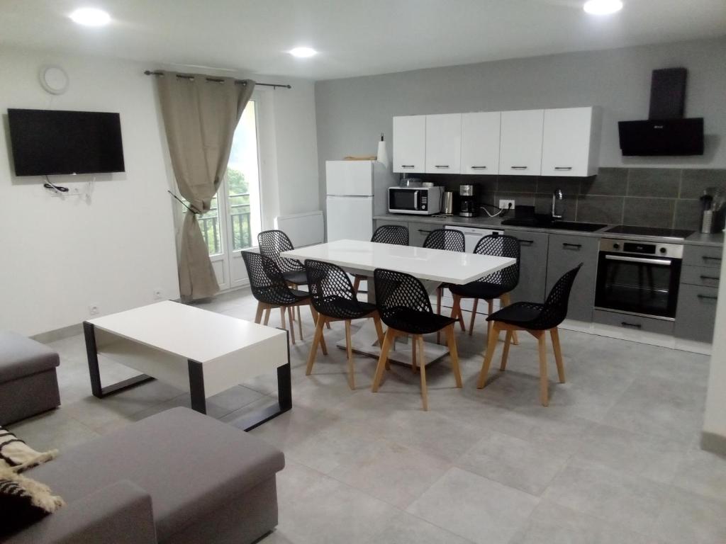 a living room with a table and chairs and a kitchen at appt tout confort a laveissiere 103 in Laveissière