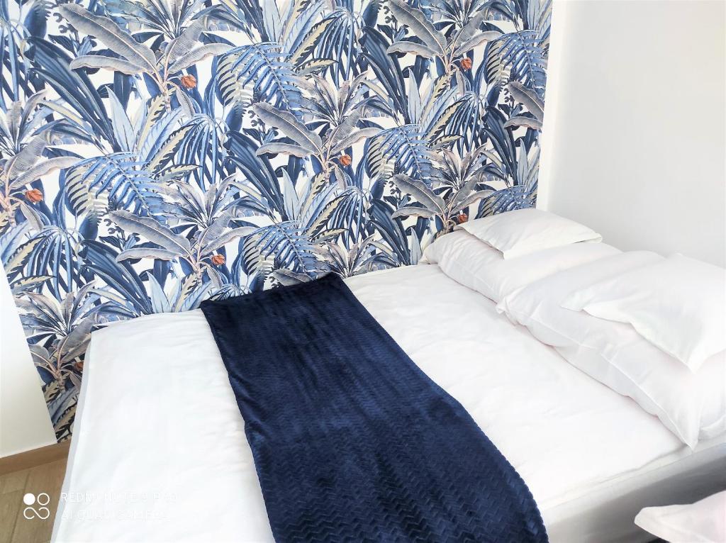 Ce lit se trouve dans un dortoir doté d'un papier peint bleu et blanc. dans l'établissement Bursztynowe Zacisze Domek 2 Chłopy ul Turystyczna 6, à Chłopy