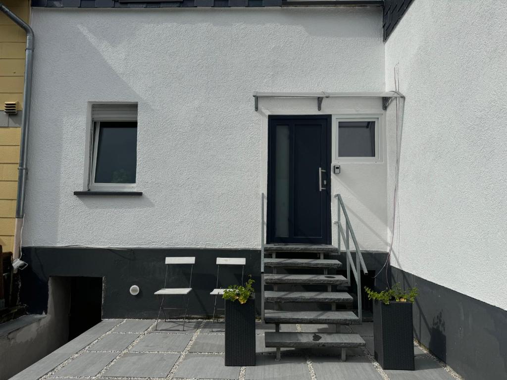 DierdorfにあるNeue Ferienwohnung Dierdorfの階段と扉のある白い家