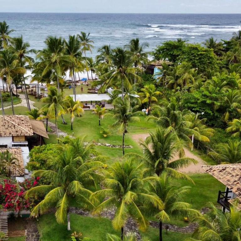 an aerial view of a resort with palm trees and the ocean at KORA MAR - Taipu de Fora - BA in Barra Grande