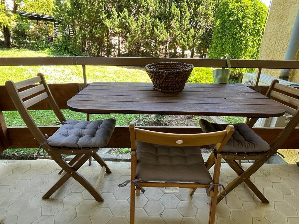 a wooden table and two chairs on a patio at Rózsakő Apartman in Balatonalmádi
