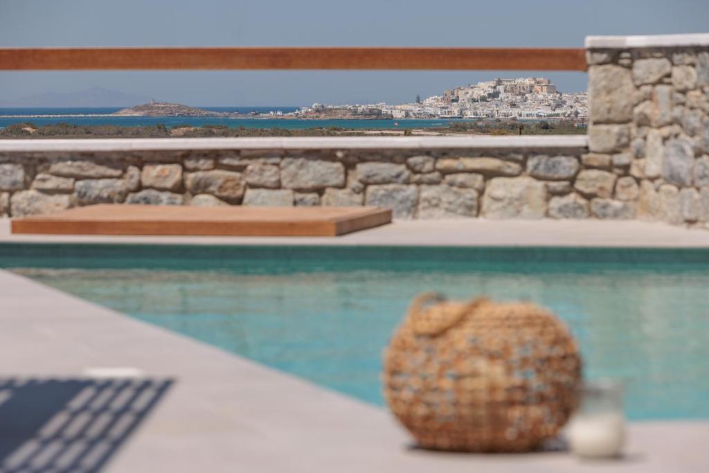 a vase sitting on a table next to a swimming pool at Velonis Villa with private pool and sea view in Agia Anna Naxos