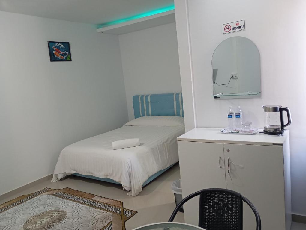 a small bedroom with a bed and a mirror at Guest House in Jodoh