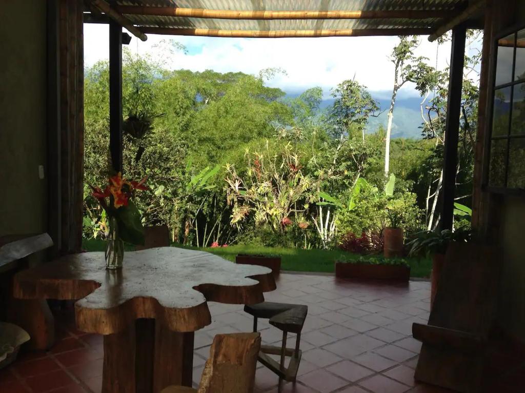 a patio with a table and chairs and a view at Charming Coffee Region Farm Escape in Armenia