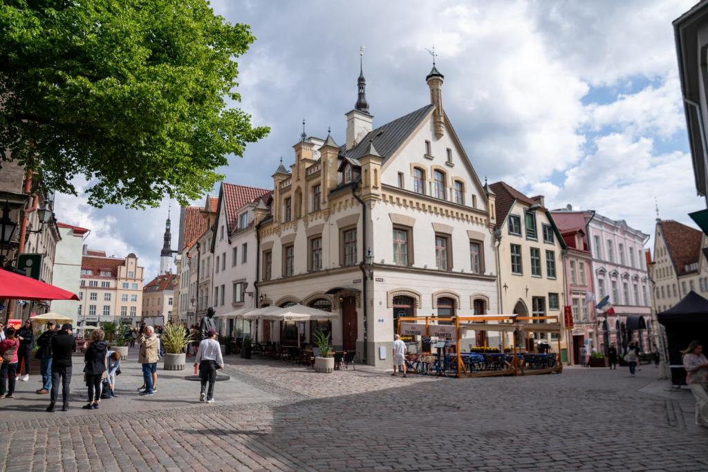 a group of people walking on a street with a building at 2BR 95m2 apartment in Old Town with Free Parking and Sauna! in Tallinn