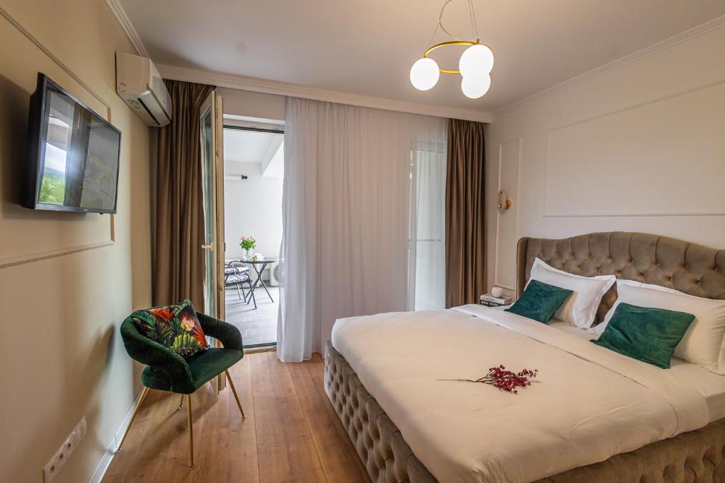 クルジュ・ナポカにあるAZABIA LUXURY APARTMENTS - Green Viewの大きなベッドと椅子のあるホテルの部屋