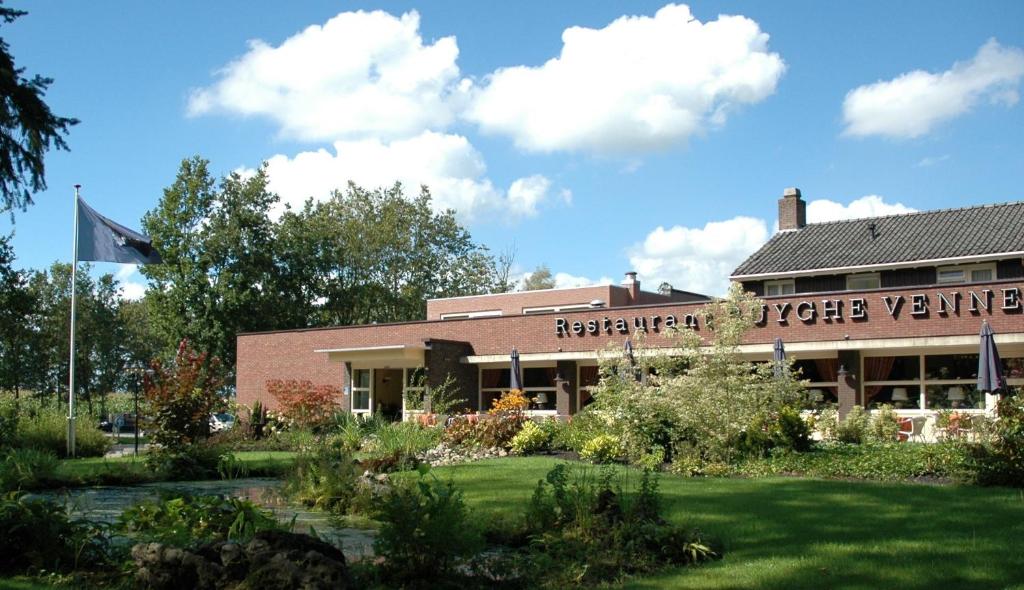 un edificio con una bandera delante de él en Hotel-Restaurant Ruyghe Venne, en Westerbork