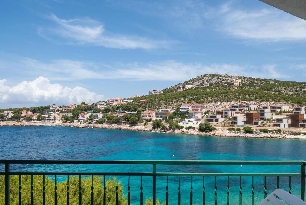 a view of a beach with houses on a hill at Apartments Ivica in Primošten