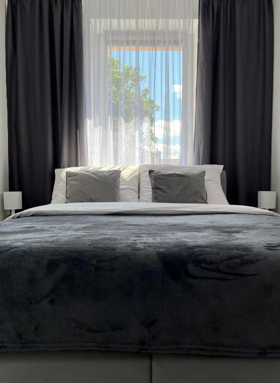 a bedroom with a large bed with a window at Apartament EROS Rynek in Bolesławiec