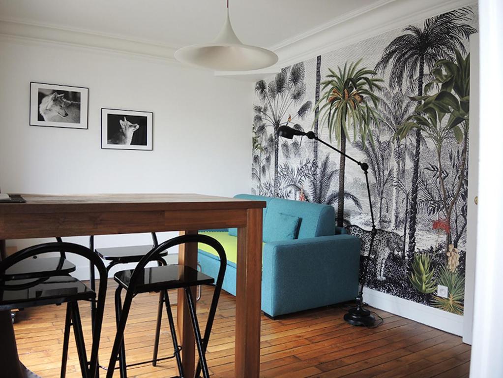 une salle à manger avec une chaise bleue et une table dans l'établissement Private Room with Bathroom in Sunny Flat, à Paris