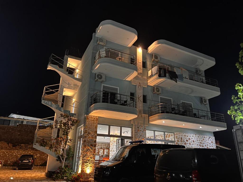 a white building with a parking lot in front of it at Vila Llaka in Himare