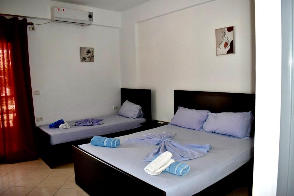 two beds in a room with purple sheets at Vila Llaka in Himare