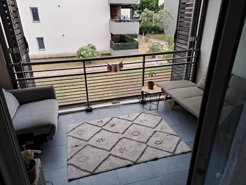- un balcon avec 2 chaises et un tapis dans l'établissement Appartement T2 avec terrasse, 5 min de la plage, à Fréjus