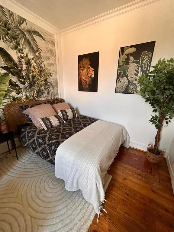 une chambre avec un lit et une plante en pot dans l'établissement Charmant appartement proche Futuroscope, à Jaunay-Clan