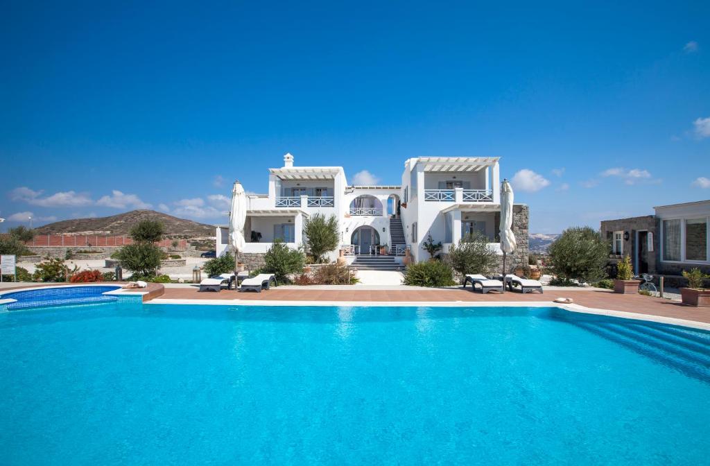 Villa con piscina frente a una casa en Miland Suites, en Adamas
