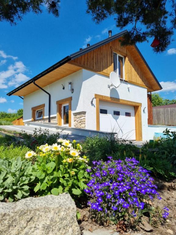 a cottage with flowers in front of it at Laki house in Jasień
