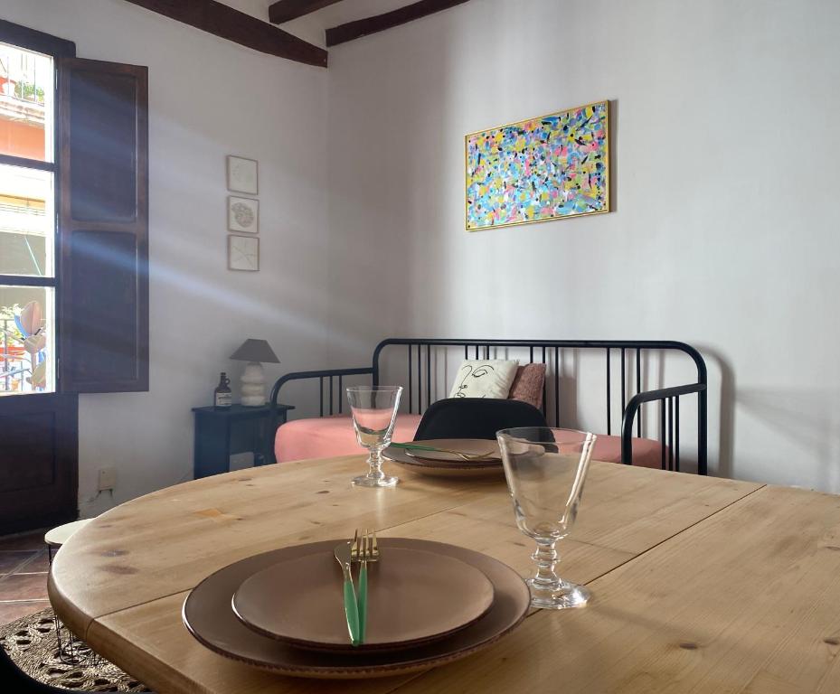 une table en bois avec deux assiettes et des verres dans l'établissement Tinos segundo, à Tarragone
