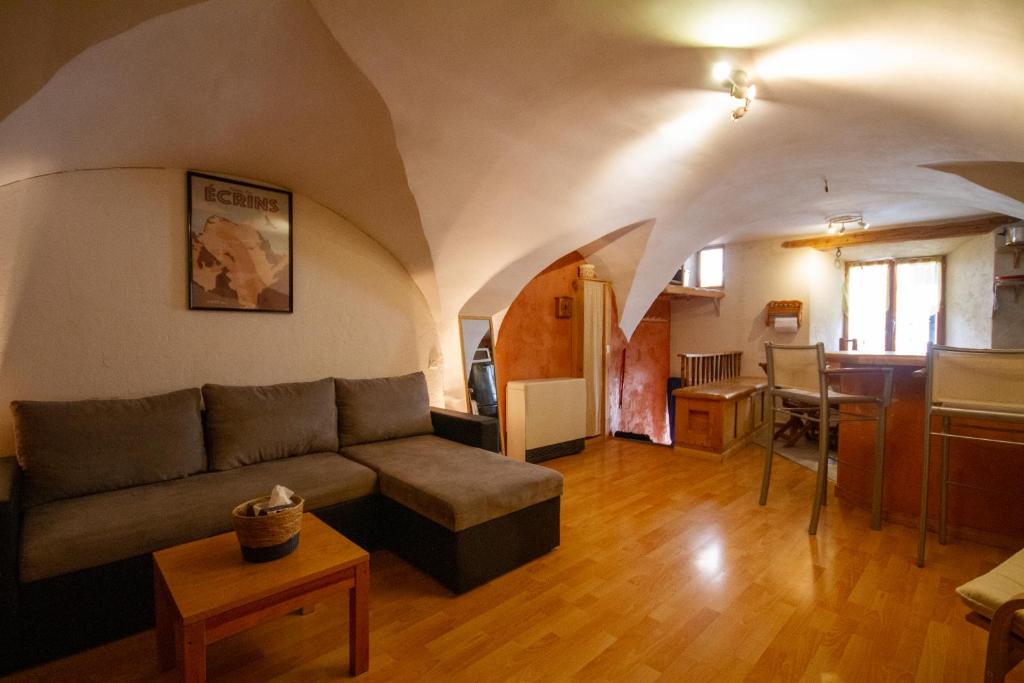 un salon avec un canapé et une table dans l'établissement Charmant Appartement de 39m2 à Guillestre, à Guillestre