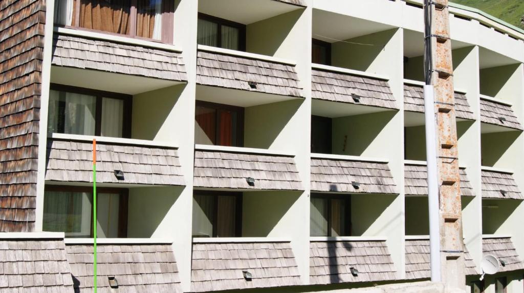 un immeuble d'appartements blanc avec un poteau en face de celui-ci dans l'établissement Drazanne, à Bagnères-de-Bigorre