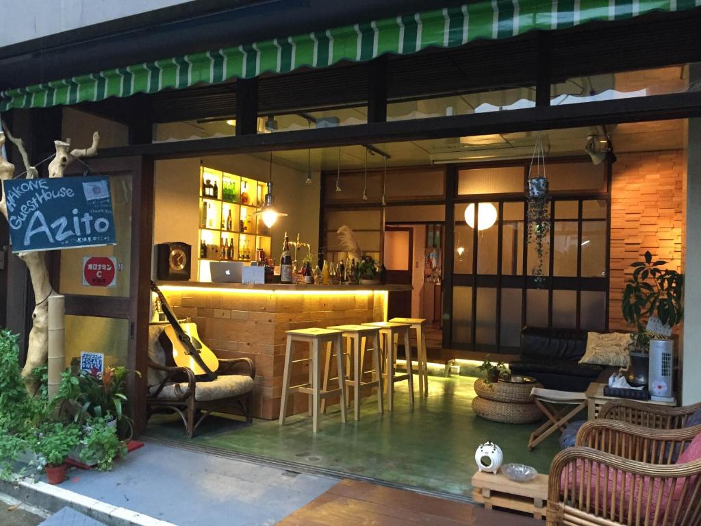 un restaurante con un bar con mesas y sillas en GuestHouse Azito, en Hakone