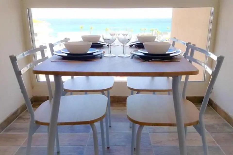 une table à manger avec des chaises, une table et une fenêtre dans l'établissement Beau studio idéalement placé avec vue mer !, à Saint-Cyprien
