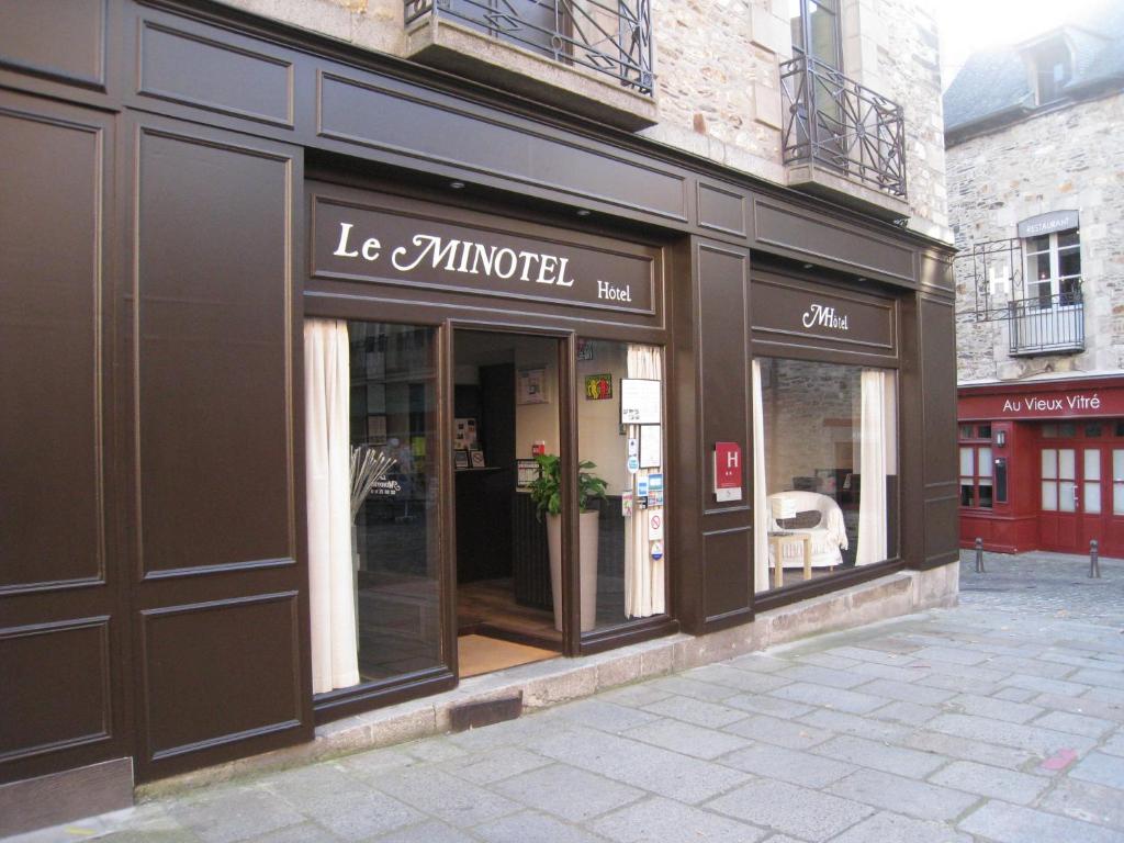 ein Geschäft vor einem Laden mit Glasfenstern in der Unterkunft Le Minotel in Vitré
