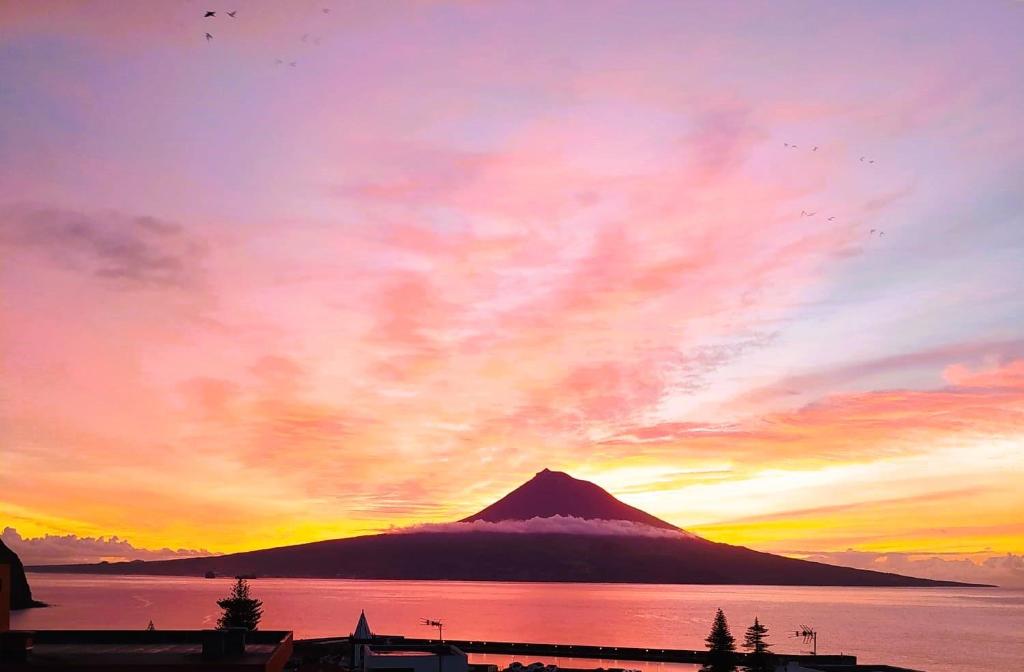 een uitzicht op een berg met een zonsondergang op de achtergrond bij Oceanus in Horta