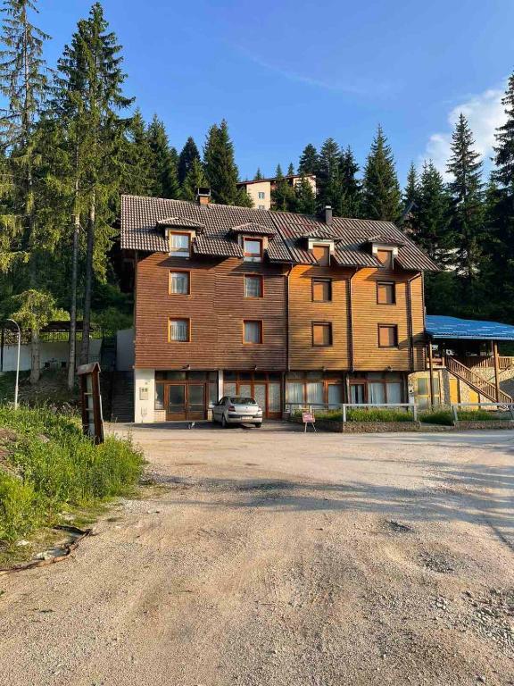 a large building with a car parked in front of it at Vila Damir in Gornja Šišava