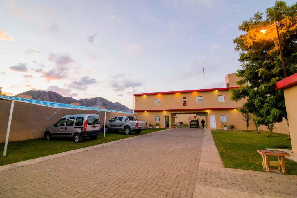 a parking lot in front of a building with two cars at Bella Vista Apart in Chilecito