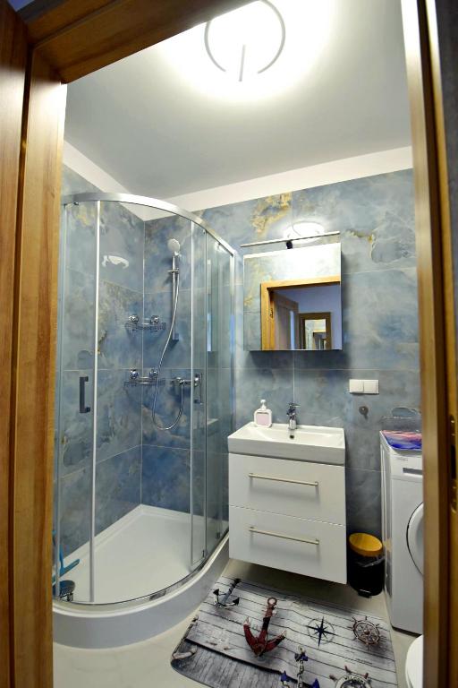 a bathroom with a shower and a sink at Apartament Muszelka 28 in Łeba