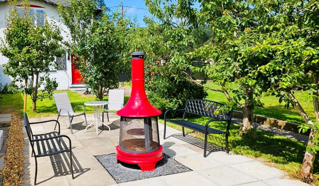 une mangeoire à oiseaux rouge est posée sur une terrasse dans l'établissement Awelfa a peaceful cottage in the Cambrian mountains, à Llanbrynmair