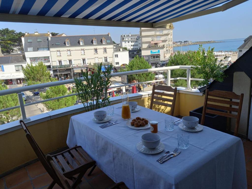 a table on a balcony with a view of a city at duplex vue mer grande plage,coeur cente ville in Quiberon