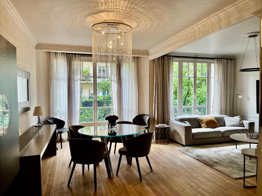 un salon avec une table, des chaises et un canapé dans l'établissement Appart PARIS 16 Auteuil-Passy Standing neuf 2ch 2sdb 2wc, à Paris