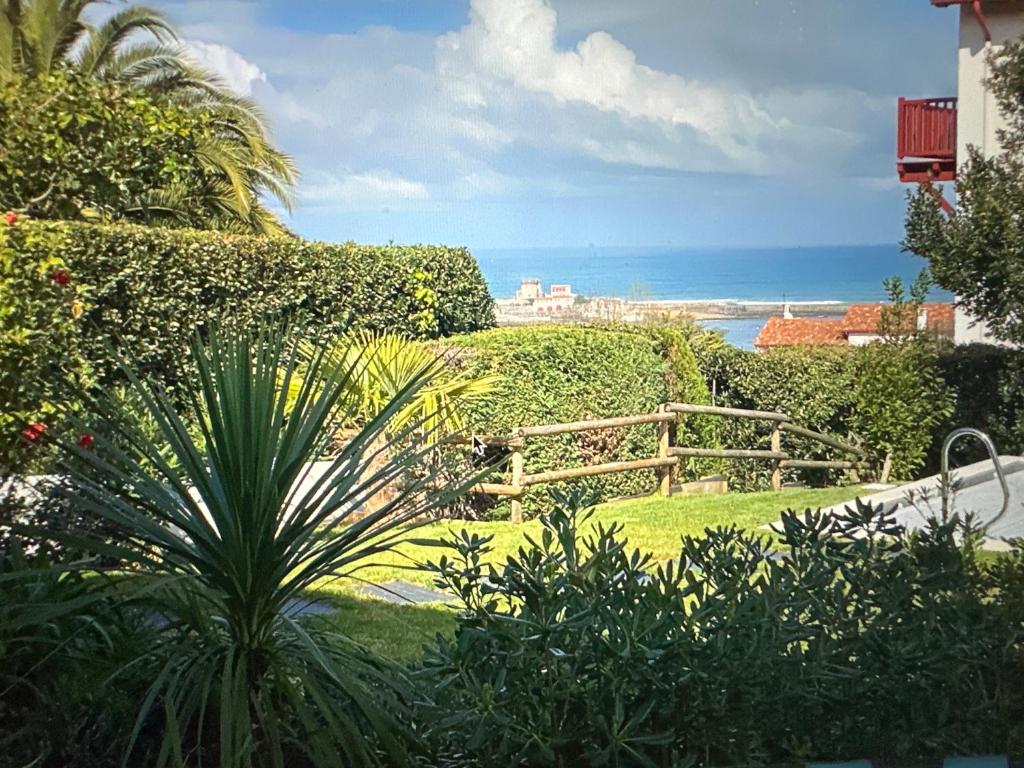 een tuin met een hek en uitzicht op de oceaan bij Argizaria in Ciboure