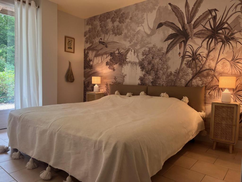 - une chambre avec un grand lit et du papier peint floral dans l'établissement Le gîte des grands arbres, à Montcaret