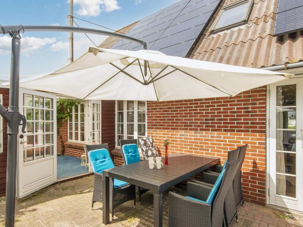 a table with a white umbrella on a patio at 10 person holiday home in Thyborøn-By Traum in Thyborøn