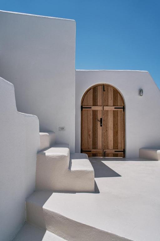 Pokój ze schodami i drewnianymi drzwiami w obiekcie The Mill Haven Santorini w mieście Oia