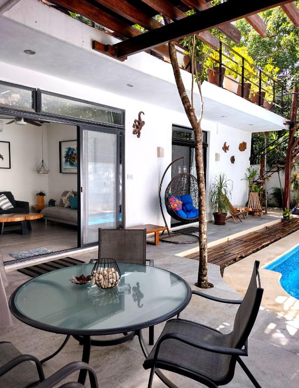 a living room with a table and chairs and a pool at Villa Tucanes in Tulum