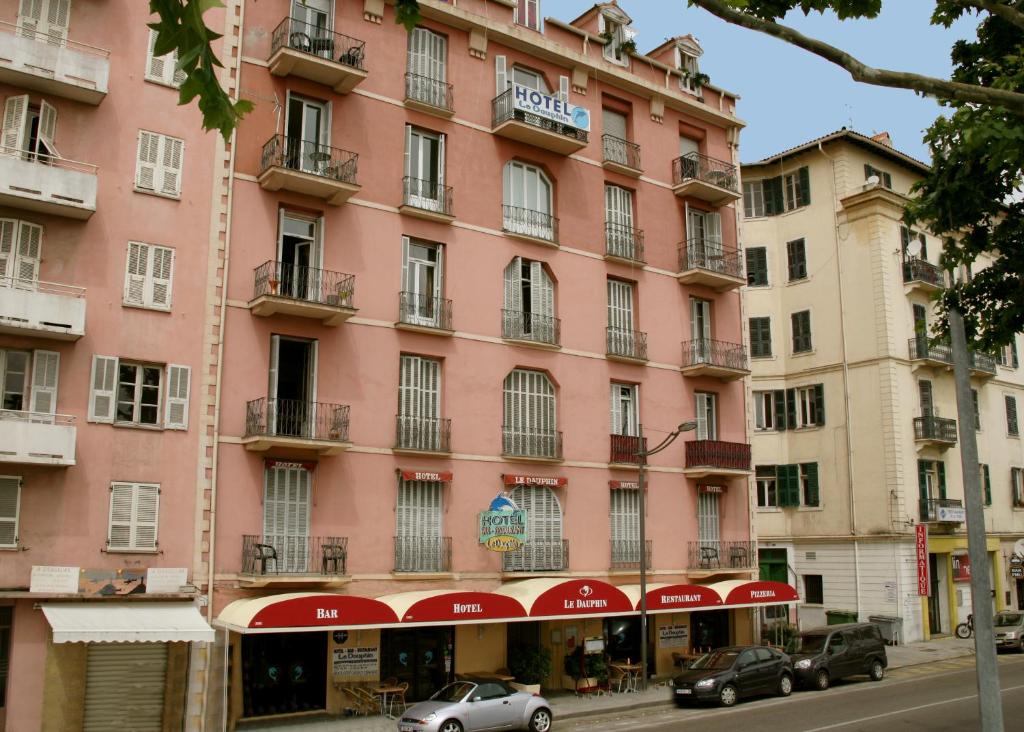 a pink building on the side of a street at Hotel le Dauphin in Ajaccio