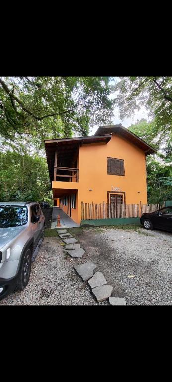a house with a car parked in front of it at Flat Maresias in São Sebastião