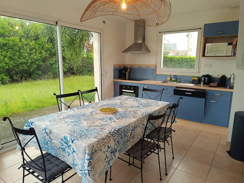 une table et des chaises dans une cuisine avec une table et une fenêtre dans l'établissement Maison 3 ch. avec jardin, terrasse et WIFI à 480m de la plage et 200m du port à Ploumanac’h - FR-1-368-429, à Perros-Guirec