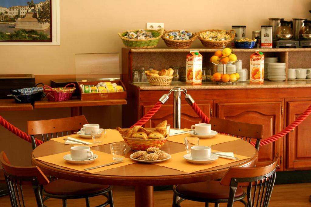 a table with a bowl of bread and a basket of fruit at Hotel le Dauphin in Ajaccio