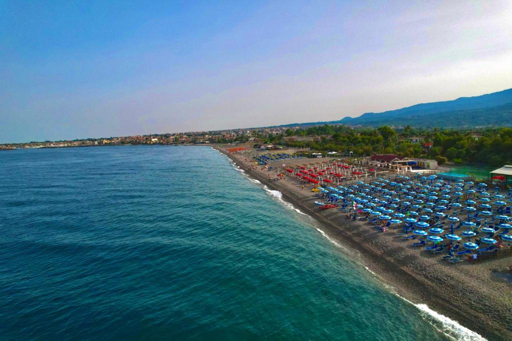Una vista aérea de una playa con sillas y sombrillas. en Monolocale al BlueMarine, en Riposto