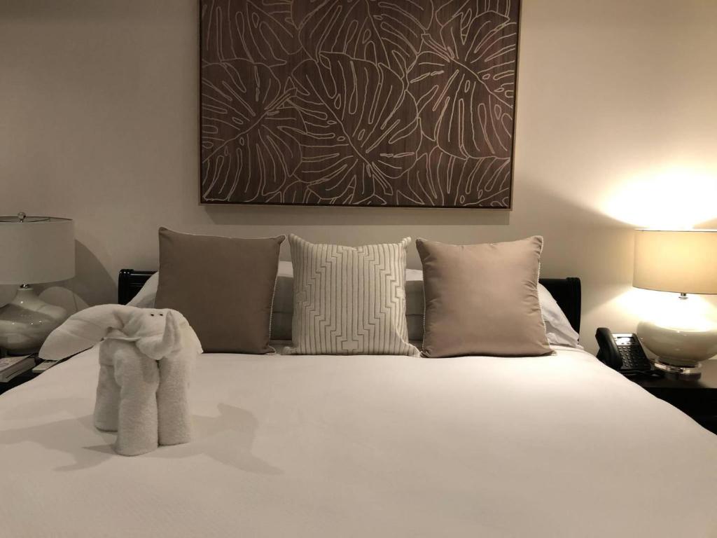 a bedroom with a large white bed with two lamps at 360 Splendor 101B Ocean View Studio With Breakfast in Playa Flamingo