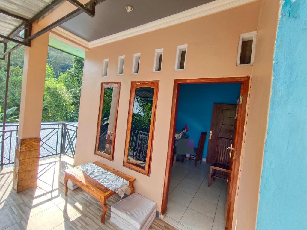 a room with a balcony with a table and chairs at Backpackers Homestay in Labuan Bajo