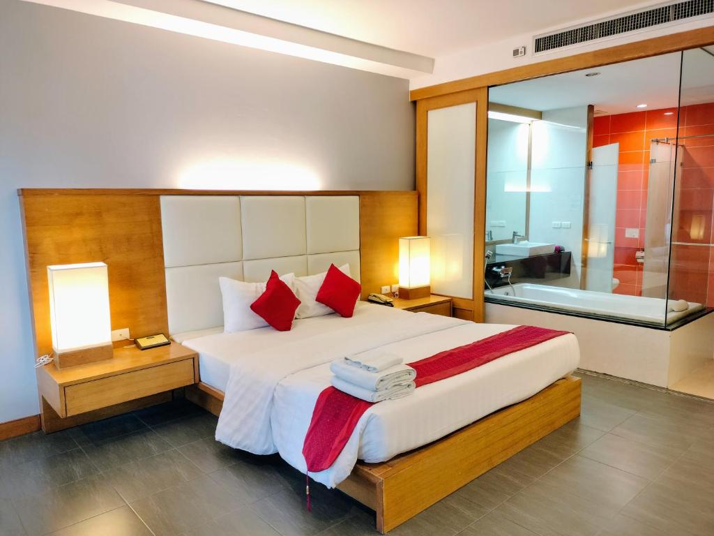 a bedroom with a bed with two lamps and a bath tub at Chang Buri Resort & Koh Chang Hillside in Ko Chang