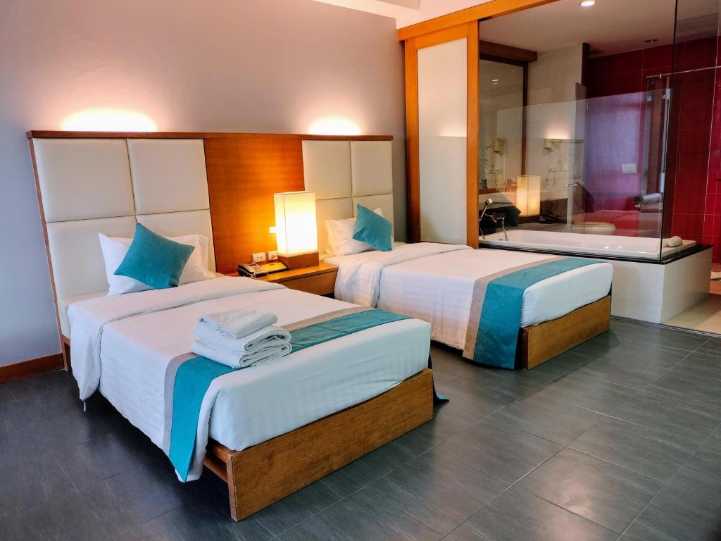 a hotel room with two beds and a bathroom at Chang Buri Resort & Koh Chang Hillside in Ko Chang