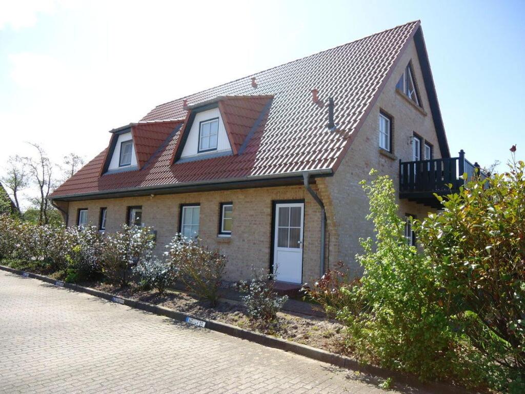 a brick house with a red roof on a street at Alter Badweg Holiday Apartment 4 in Sankt Peter-Ording